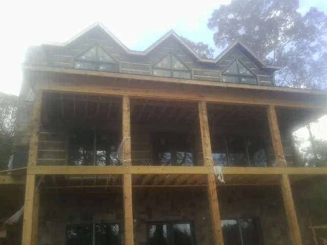 Dormers and porch framing on a large log home under construction — Roof Coating work by our crew in Mukilteo