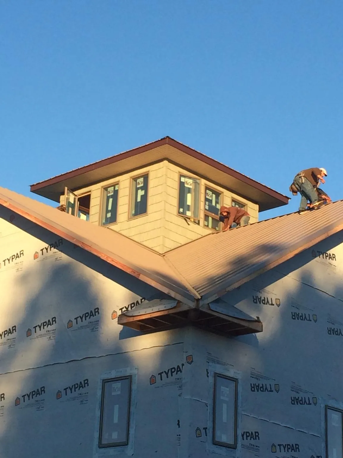 Roofers working around a rooftop cupola on a new metal roof at sunset — Roof Waterproofing in Mukilteo by Roofing Brothers